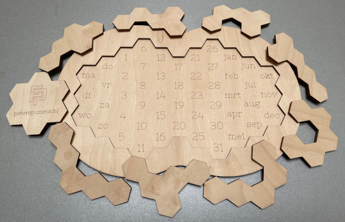 Photo of an empty board of calendar puzzle "Hexagon" with all 9 pieces around it